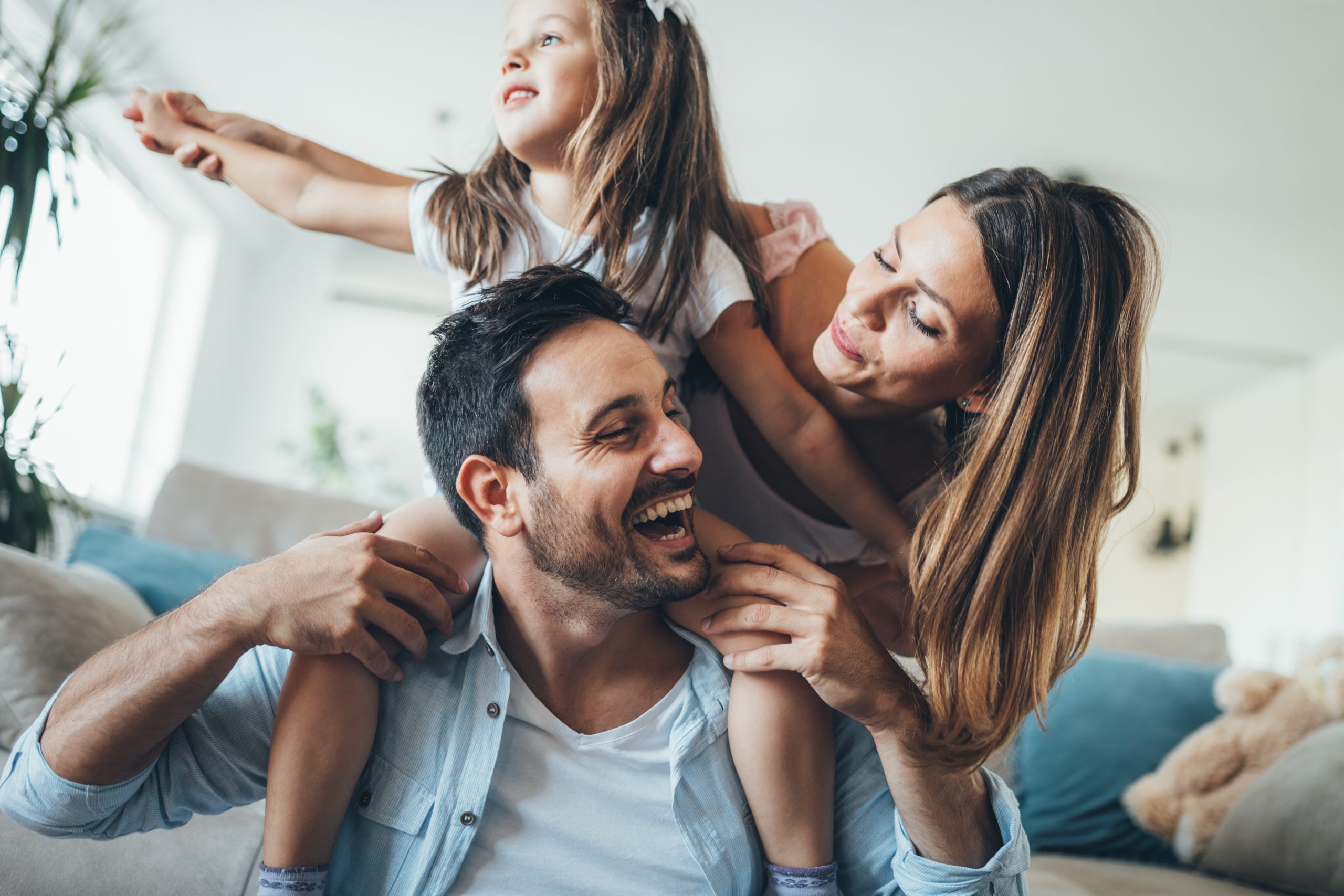 An image of a man and woman playing with their daughter in happy times